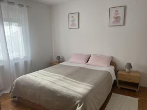 a bedroom with a bed with pink pillows and a window at Medulin Burle A4 1 in Medulin