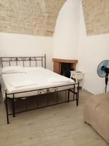 een slaapkamer met een bed in een kamer met een open haard bij La piccola casa di Tania in via Fiore in Terlizzi
