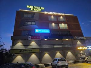 a building with cars parked in front of it at Hotel Vivan Inn in Himatnagar