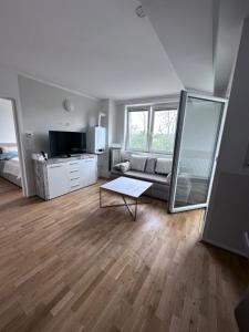 ein Wohnzimmer mit einem Sofa und einem Tisch in der Unterkunft Sunny Apartments Podersdorf am See in Podersdorf am See