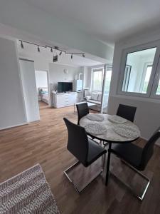 a room with a table and chairs and a living room at Sunny Apartments Podersdorf am See in Podersdorf am See