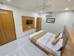 a bedroom with a bed and a television in it at Hotel Vivan Inn in Himatnagar