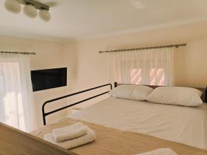 a bedroom with a bed with two towels on it at Lucy's luxury II in Néa Koútali