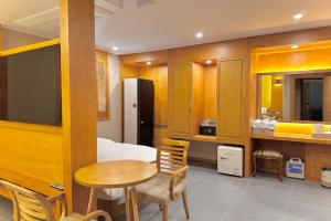Zimmer mit einem Tisch und einer Küche mit einem Kühlschrank. in der Unterkunft Sokcho Mir Hotel in Sokcho