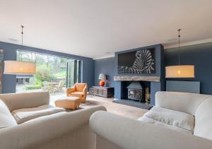 uma sala de estar com dois sofás e uma lareira em St Marys em Little Petherick