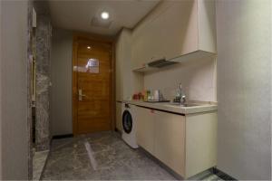 a small kitchen with a sink and a washing machine at MIZPARTON HOTEL - Heshan New Town in Jiangmen