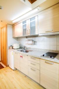 a kitchen with wooden cabinets and a sink at Wellihilli Park Resort in Hoengsong