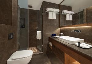 a bathroom with a toilet and a sink and a shower at Fortune Park, East Delhi - Member ITC Hotels' Group in New Delhi