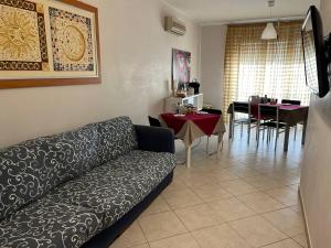 a living room with a couch and a dining room at B&B PIAZZA KOLBE in Acquaviva delle Fonti
