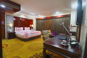 a hotel room with a bed and a desk at SkyCity Hotel Gurgaon in Gurgaon