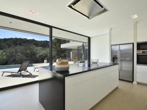 a kitchen with white cabinets and a view of a patio at Villa Clarisse in Tamariu