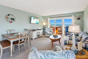 a living room with a table and a dining room at C223C Daze Aaah View Oceanfront Community Pool in Duck