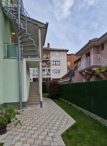 a house with a staircase in a yard at Apartman Viking in Donji Milanovac