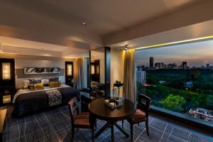 a bedroom with a bed and a table and a large window at Hotel New Otani Tokyo EXECUTIVE HOUSE ZEN in Tokyo