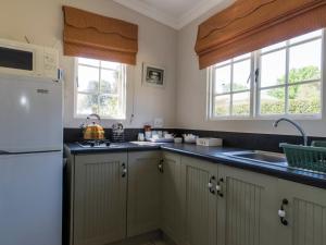 a kitchen with a white refrigerator and a sink at Old Rearsby in Mooirivier