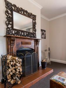 a fireplace with a mirror above it in a living room at Old Rearsby in Mooirivier