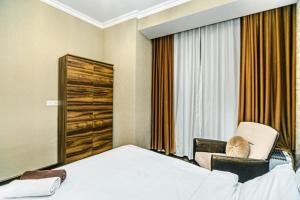 um quarto de hotel com uma cama e uma cadeira em City Centre DeLuxe em Baku