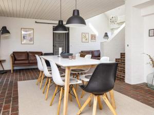 a dining room with a white table and chairs at 8 person holiday home in Rømø-By Traum in Kongsmark +34 photos