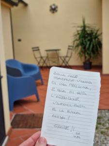 une personne détenant un morceau de papier avec écriture sur celui-ci dans l'établissement Casa Marcobando, à Lucques