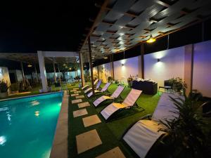 a row of lounge chairs next to a pool at night at Pereira lounge bar in Praia