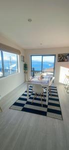 uma sala de jantar com uma mesa e vista para o oceano em Sea views from sunny house em Wellington
