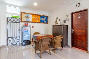 a dining room with a table and chairs and a refrigerator at Capital O 93944 Geweka Homestay in Jimbaran