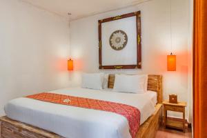 Schlafzimmer mit einem Bett und einem Spiegel an der Wand in der Unterkunft Capital O 93944 Geweka Homestay in Jimbaran