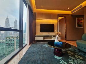 uma sala de estar com televisão e uma grande janela em Imperial Luxury Suites KLCC by Moonway em Kuala Lumpur