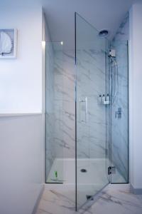 a shower with a glass door in a bathroom at Stylish 2-Bedroom Haven Next to Hagley Park in Christchurch