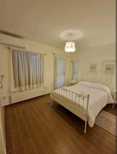 ein weißes Schlafzimmer mit einem Bett und einem Kronleuchter in der Unterkunft Butterfly Home in Platres