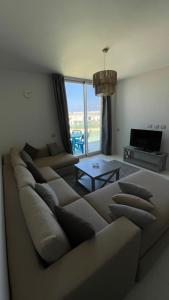 a living room with a large couch and a television at Fouka bay chalet at north coast, Egypt in Marsa Matruh