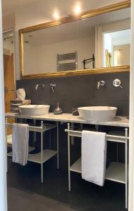 a bathroom with two sinks and a large mirror at CMH Castello Suites in Cagliari +10 photos