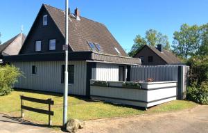 a house with a fence and a bench in front of it at Ferienwohnung - Michaelas HUUS - zwischen den Meeren, Trappenkamp in Trappenkamp +16 photos