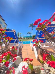 un grupo de sillas blancas junto a una piscina en Hotel Combarro en Combarro