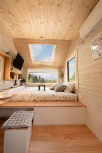a bedroom in a tiny house with a large window at Aurora Green Hill in Podobin
