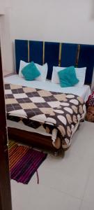 een bed met een geruite deken en kussens bij Arora guest house in Amritsar