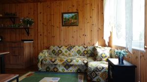 sala de estar con sofá en una habitación con paredes de madera en Дом для відпочинку, у парку, на березі моря en Tolokun