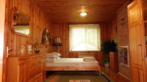 - une chambre avec un lit dans une pièce en bois dans l'établissement Дом для відпочинку, у парку, на березі моря, à Tolokun