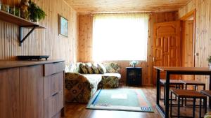 a living room with a couch and a window at Дом для відпочинку, у парку, на березі моря in Tolokun