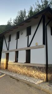 a white building with black windows on it at Studio Apartment in Bihać