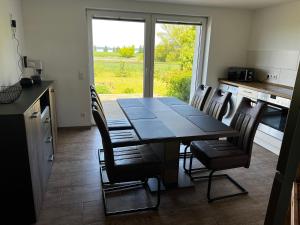 a dining room with a table and chairs in a kitchen at Ferienwohnung Seeblick in Retgendorf