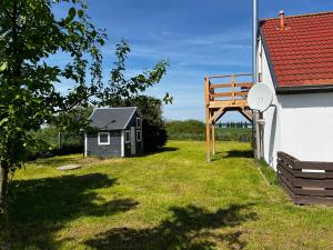 a small house with a wooden structure next to a building at Ferienwohnung Seeblick in Retgendorf