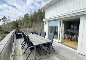 a wooden deck with a table and chairs on it at Lovely villa with a view of the Byfjorden and Uddevalla in Uddevalla