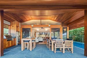 an open kitchen and dining room with wooden ceilings at 23 The Cove - Whitsunday Waterfront Living in Airlie Beach