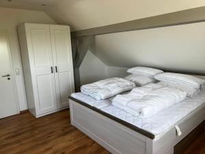 a bedroom with a bed with white sheets and pillows at Ferienwohnung Seeblick in Retgendorf