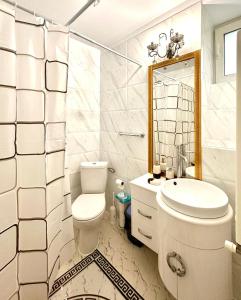 Un baño blanco con inodoro y lavabo. en NEW Burgeois Berindey Apartment - Universitate, en Bucarest
