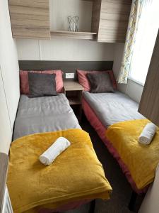 2 camas en una habitación de color amarillo y gris en LOIRE, en Skegness