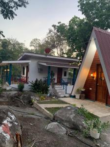 a small white house with a red roof at Camp Asgard by Camiguin Viajeros House Rentals in Catarman