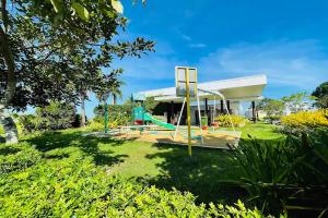 Shiella's Staycation House Cabanatuan في كاباناتوان: ملعب في حديقة مع مبنى