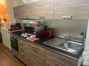 a kitchen with a sink and a microwave at Duplex Face au Palais in Avignon
